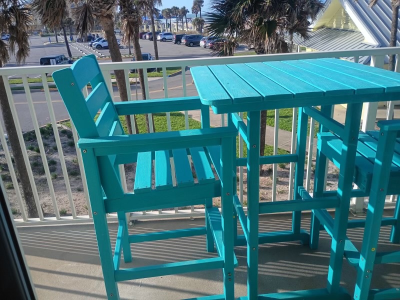 Your private balcony features bright turquoise seating perfect for morning coffee or evening cocktails. The beach just steps away.