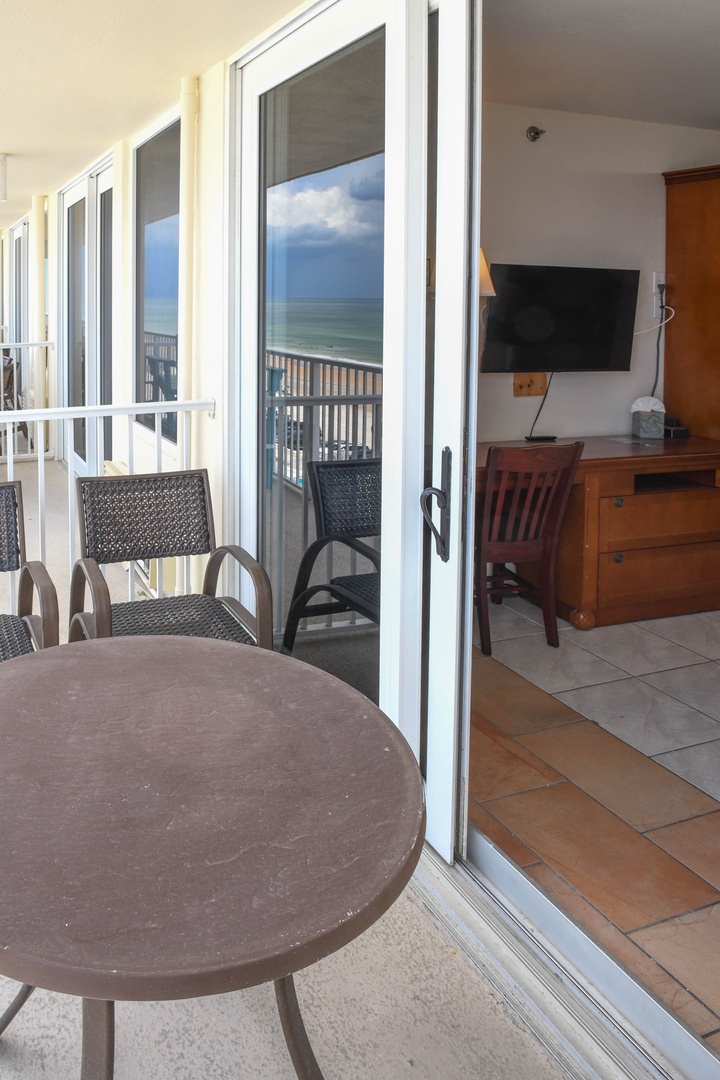 Picture yourself relaxing on your private balcony with breathtaking ocean views, enjoying your morning coffee at this cozy table. Step inside to a comfortable living space with beach-inspired furnishings perfect for unwinding after a day in the sun.