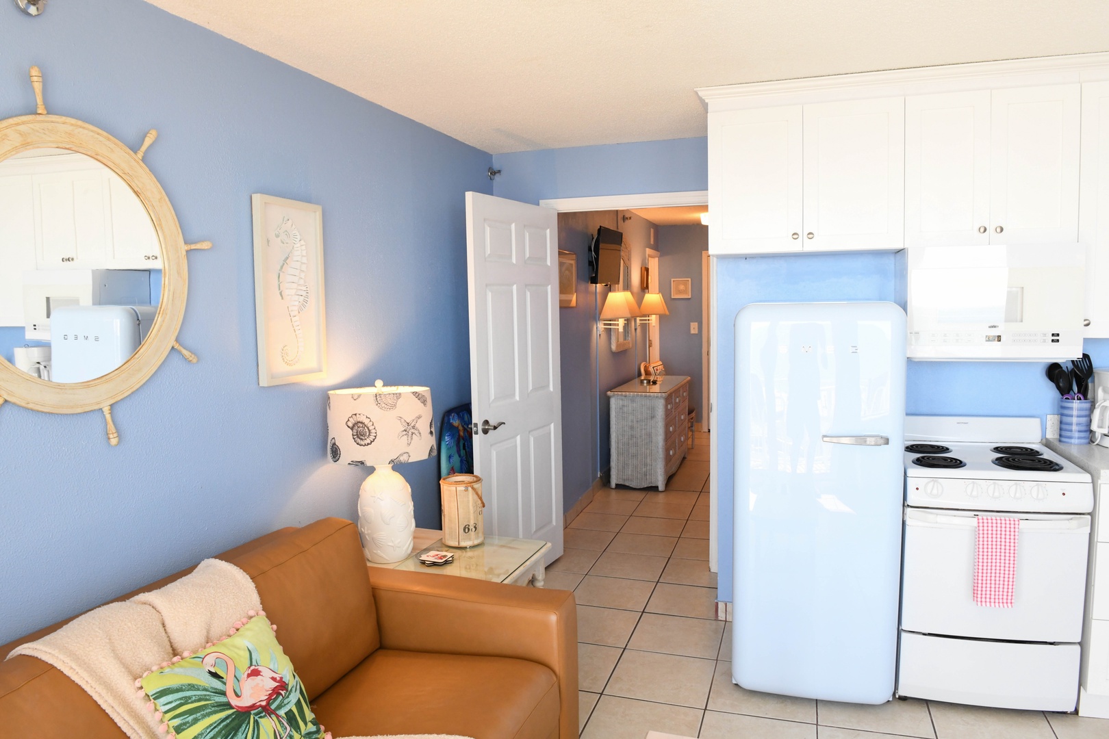Relax in your charming coastal-themed space with a full kitchen, retro fridge, and playful nautical touches that make your beach getaway feel like home.