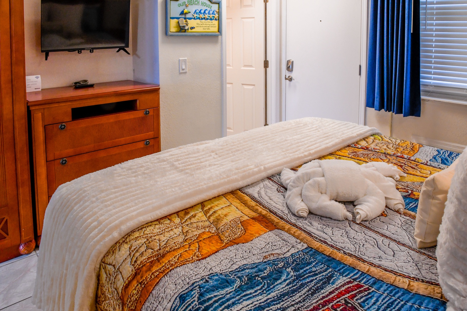 Sink into your cozy bedroom, complete with a plush bed, wall-mounted TV, and thoughtful beach-themed touches. Fresh towels await your arrival.