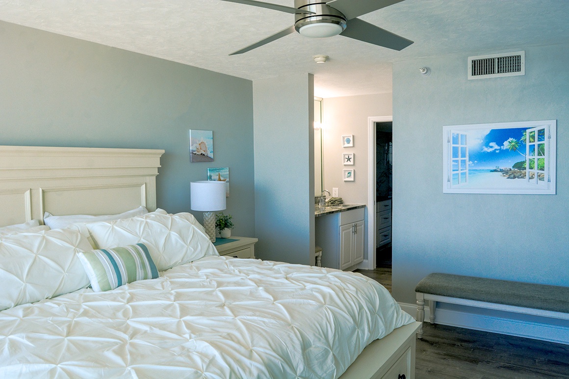 Drift into peaceful slumber in your serene coastal bedroom with tropical wall art and crisp linens.