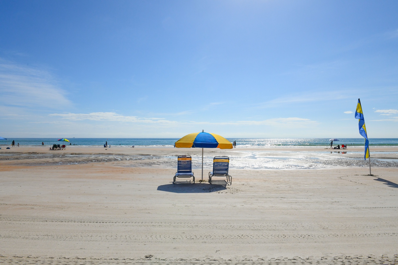 Sandy beach with calm waves just steps away, featuring a shaded lounge setup where you can relax and soak in the coastal scenery throughout the day.