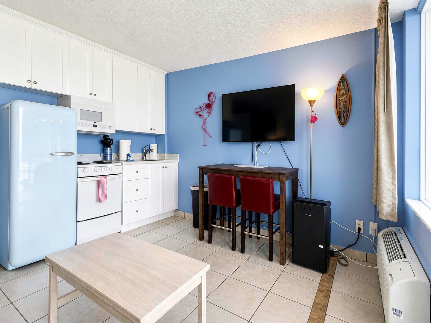 Your bright coastal retreat features a fully equipped kitchen with retro-style appliances, a cozy dining nook, and fun flamingo touches that set a beachy, playful tone.