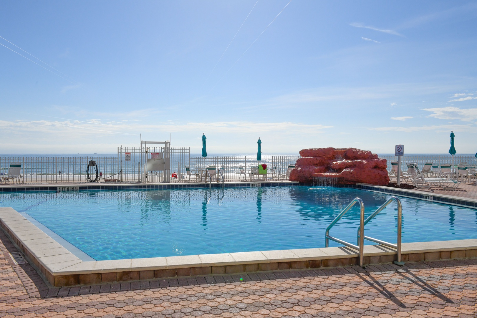 A sparkling beachfront pool awaits your arrival, framed by ocean views and shaded seating areas where you can lounge in comfort throughout your stay.