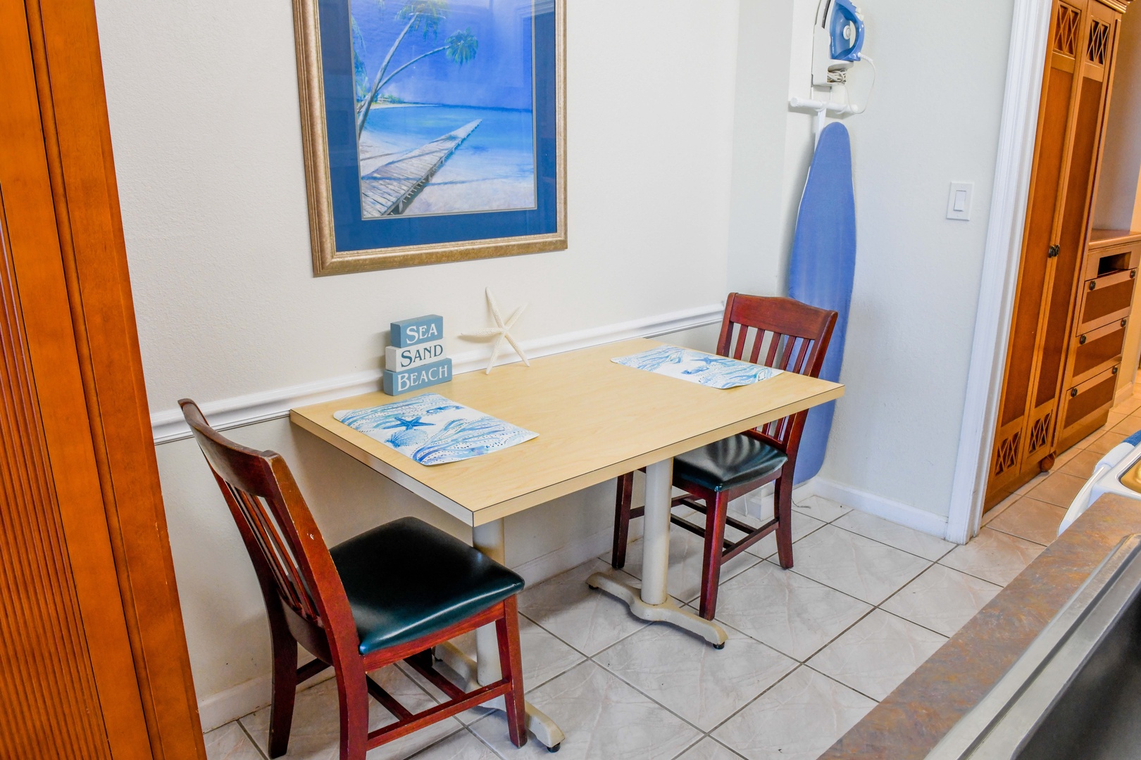 Enjoy your morning coffee or casual meals at this cozy dining nook, featuring beach-themed decor and comfortable seating that brings coastal charm to your stay.