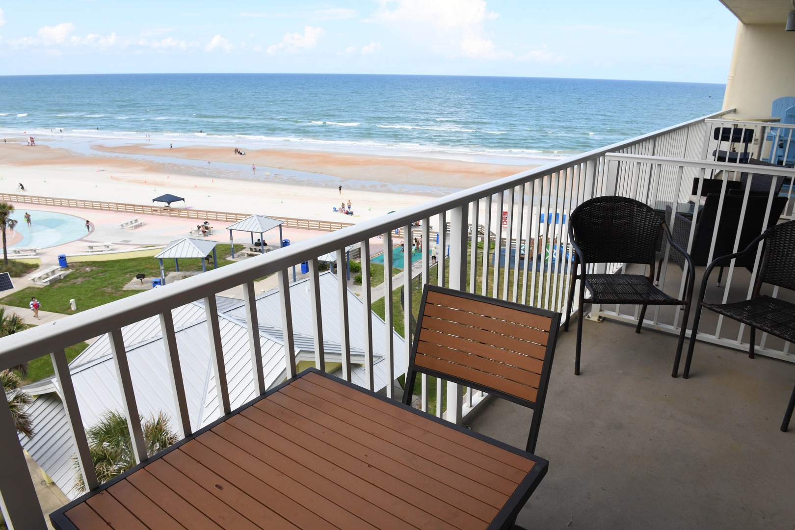 Sweeping oceanfront views stretch before you from this expansive balcony, where morning coffee and sunset moments become daily rituals overlooking the sandy beach and sparkling waves below.
