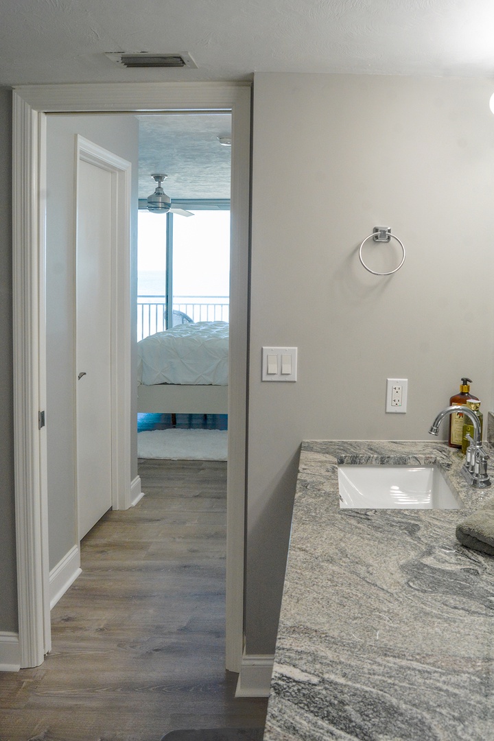 Your private ensuite bathroom features elegant marble countertops and connects directly to your oceanfront bedroom.