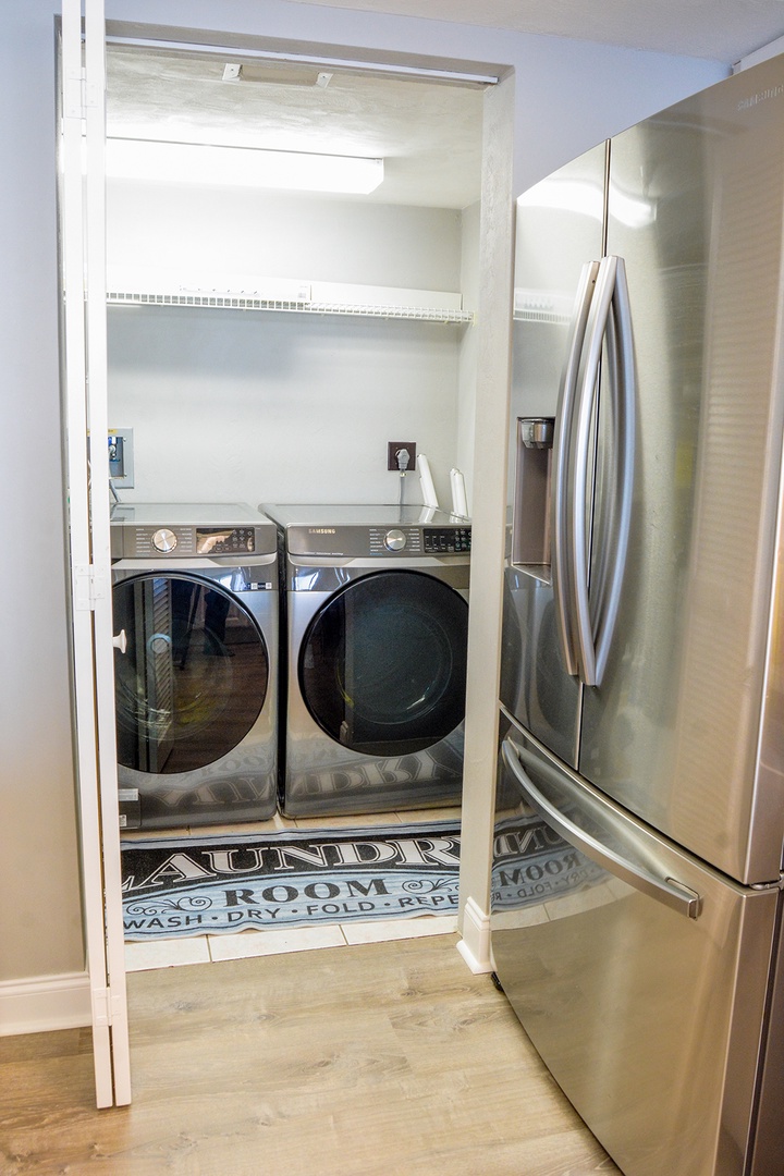 Convenient in-unit laundry nook keeps your vacation wardrobe fresh with modern washer and dryer tucked neatly behind sleek doors.