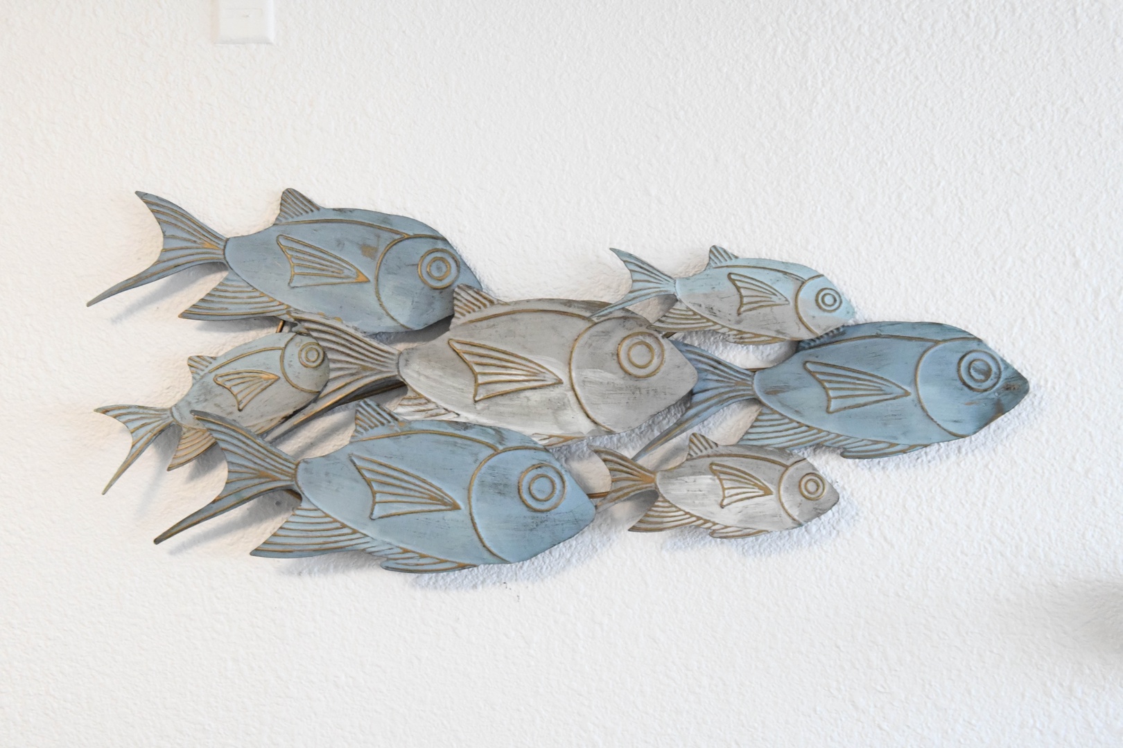 Coastal charm meets artistic flair. This hand-carved school of fish brings a playful, beach-inspired accent to your home away from home.