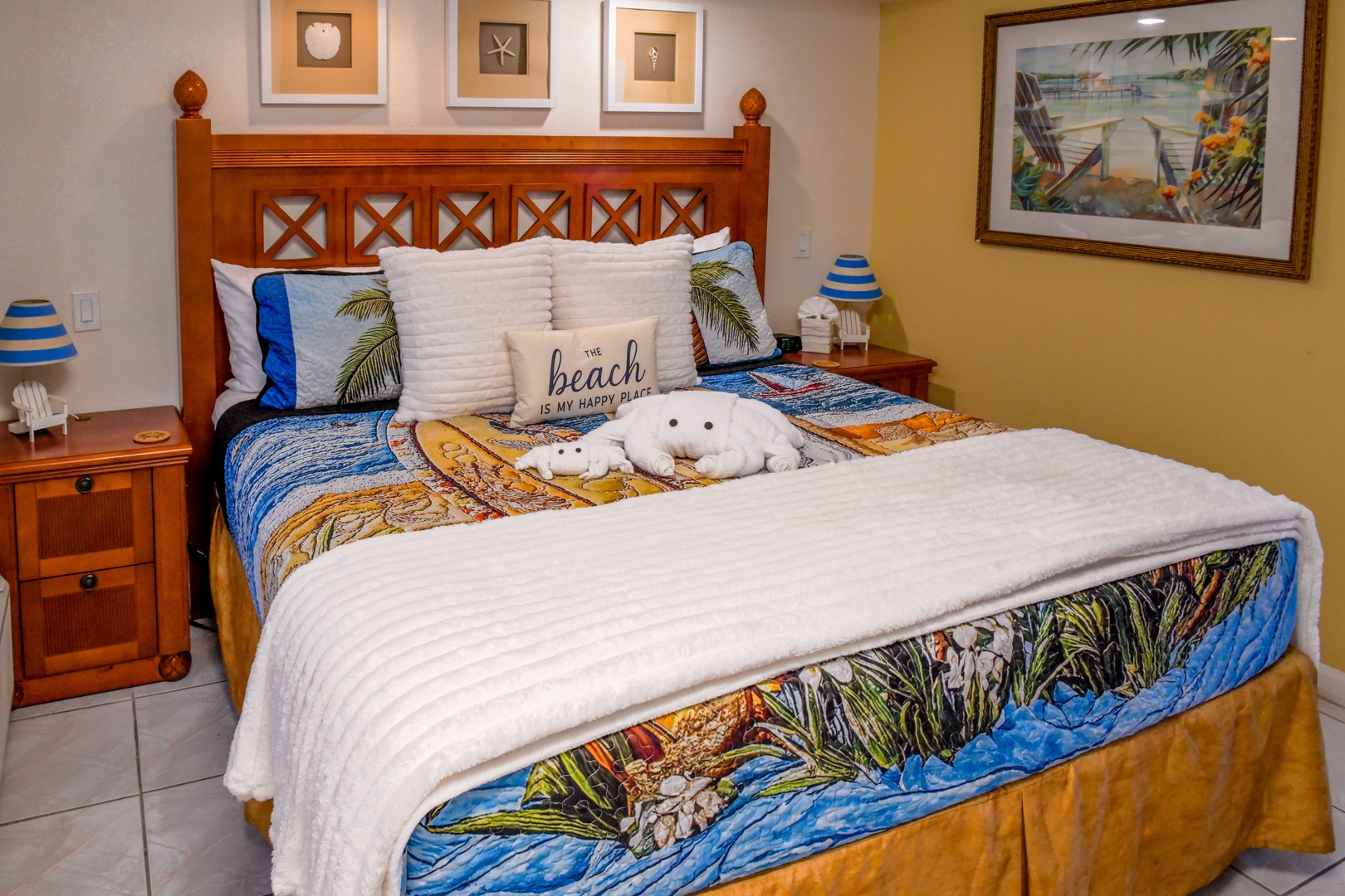 Sink into your coastal retreat with a plush bed dressed in tropical linens. Beach-themed décor and warm wood tones create the perfect escape for your sunny getaway.