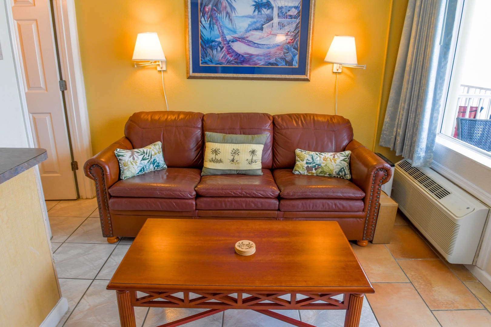 Sink into rich leather comfort in your living area, where warm tones and coastal artwork create the perfect spot to unwind after a day of exploring.