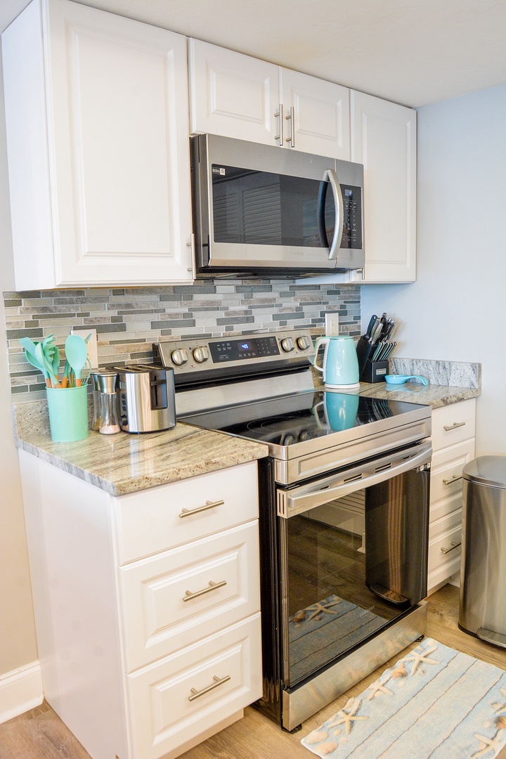 Cook your favorite meals in this bright, fully-equipped kitchen with stainless steel appliances and coastal-inspired design.