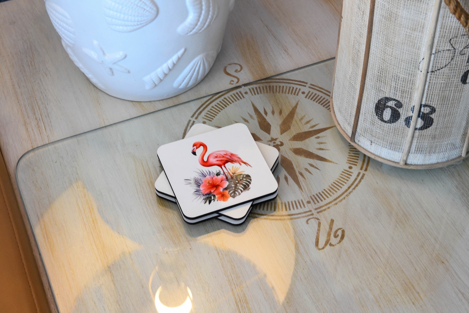 Charming coastal details greet you—a compass rose table, tropical coasters, and beachy accents create a warm, relaxed vibe.