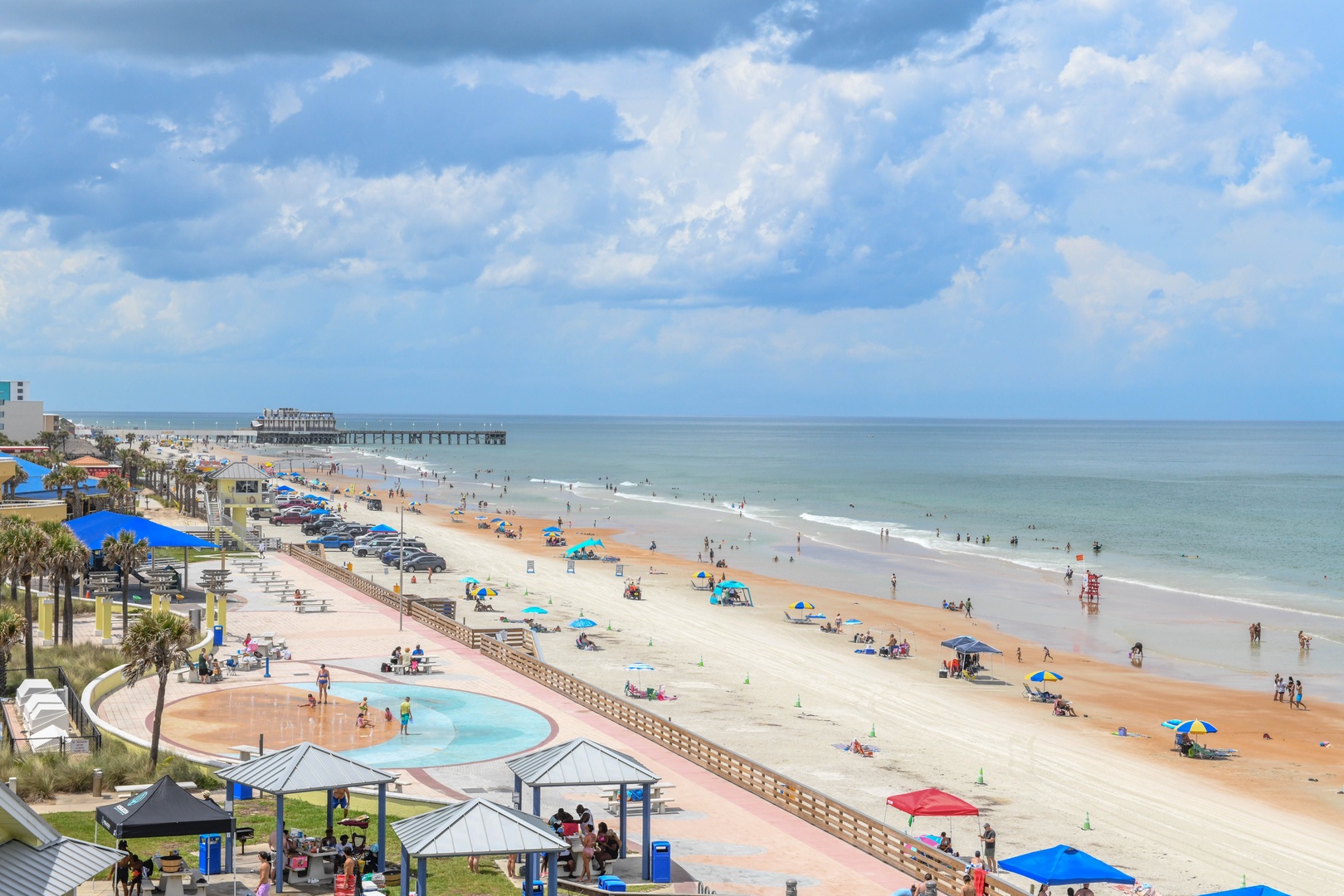 Daytona Beach stretches along the Atlantic Ocean, featuring a wide sandy shore, historic pier, palm-lined boardwalk, and beachfront amenities serving this popular coastal destination.