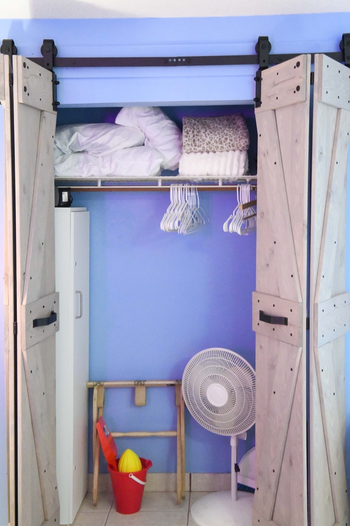 Store your belongings in this convenient closet featuring a hanging rod, upper shelf space, and barn-style doors for easy access during your stay.