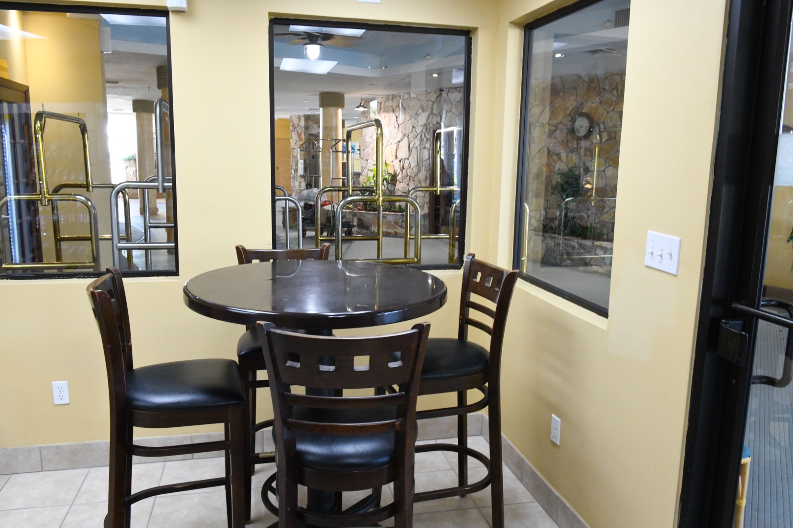 A communal dining area with a round table and chairs offers a welcoming spot to share meals, with large windows.