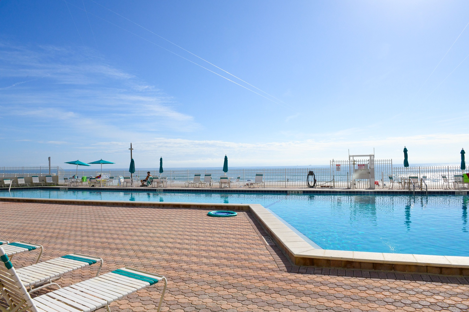 Sparkling pool meets endless ocean views, with lounge chairs and umbrellas ready for your perfect sunny day by the sea.