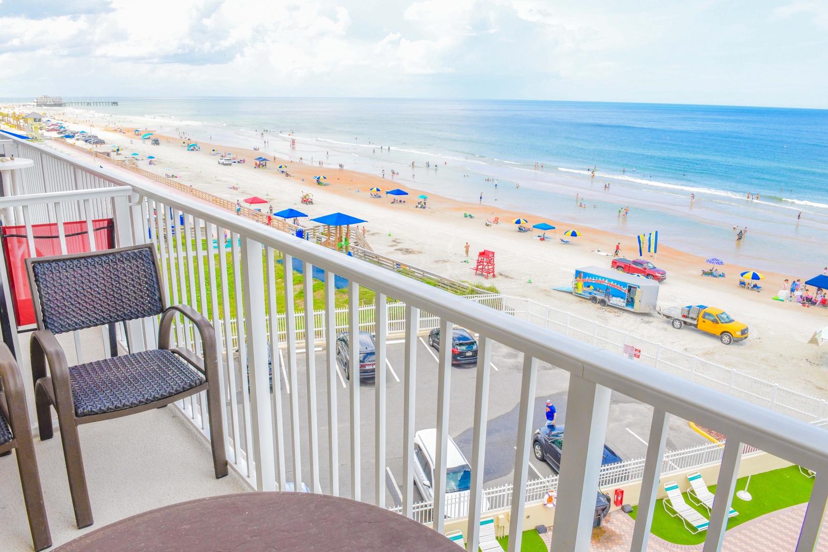 Step onto your private balcony and take in sweeping views of golden sands, turquoise waters, and colorful umbrellas dotting the shore—your perfect beach getaway awaits.