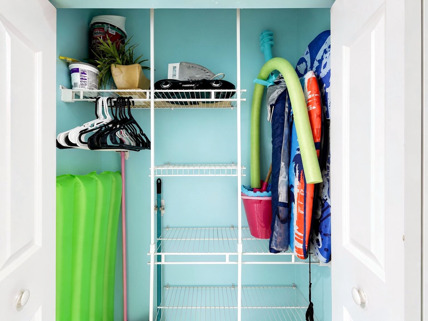 Your beach day essentials are ready and waiting—pool noodles, towels, and gear all stored in a vibrant, cheerful closet that promises fun in the sun.