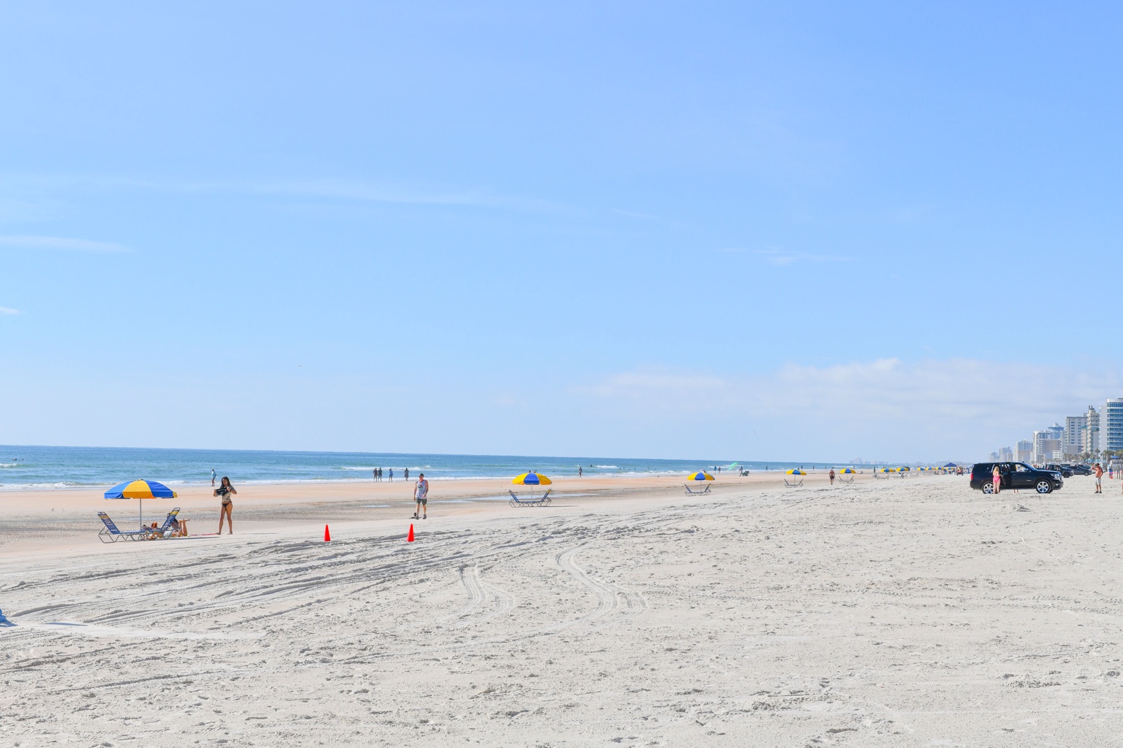 Wide sandy beach stretches along the ocean with city skyline visible in the distance, offering coastal access near the property.