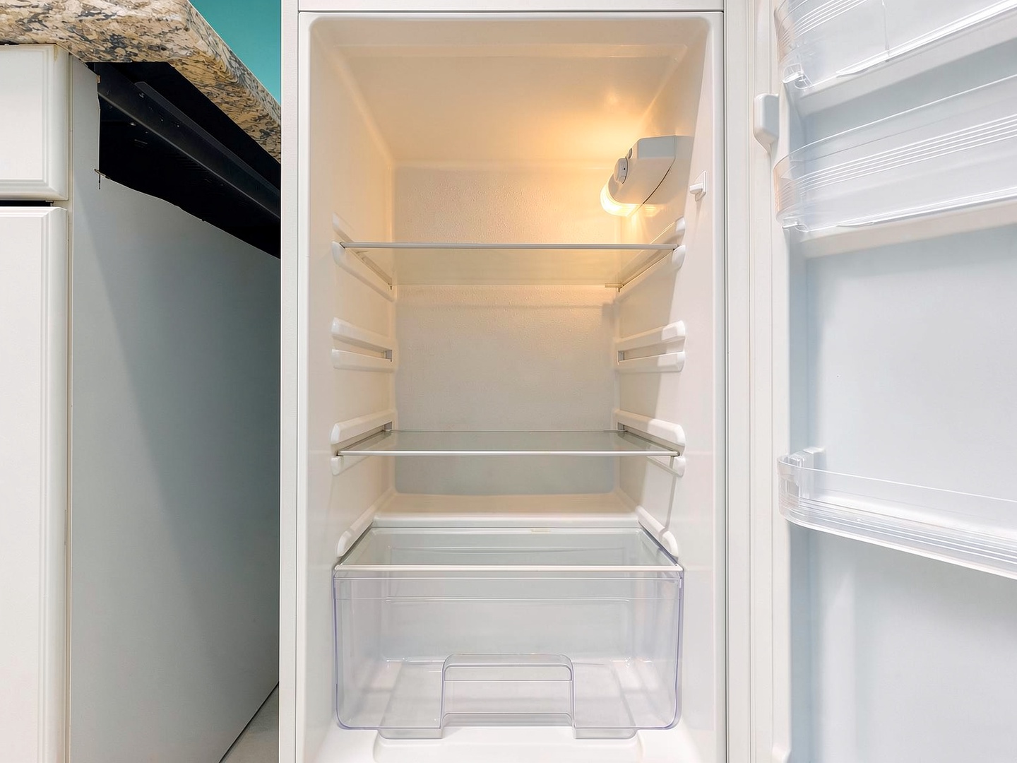 Your fully-equipped kitchen includes a spacious refrigerator with clean shelves and plenty of storage for all your groceries and fresh finds from local markets.