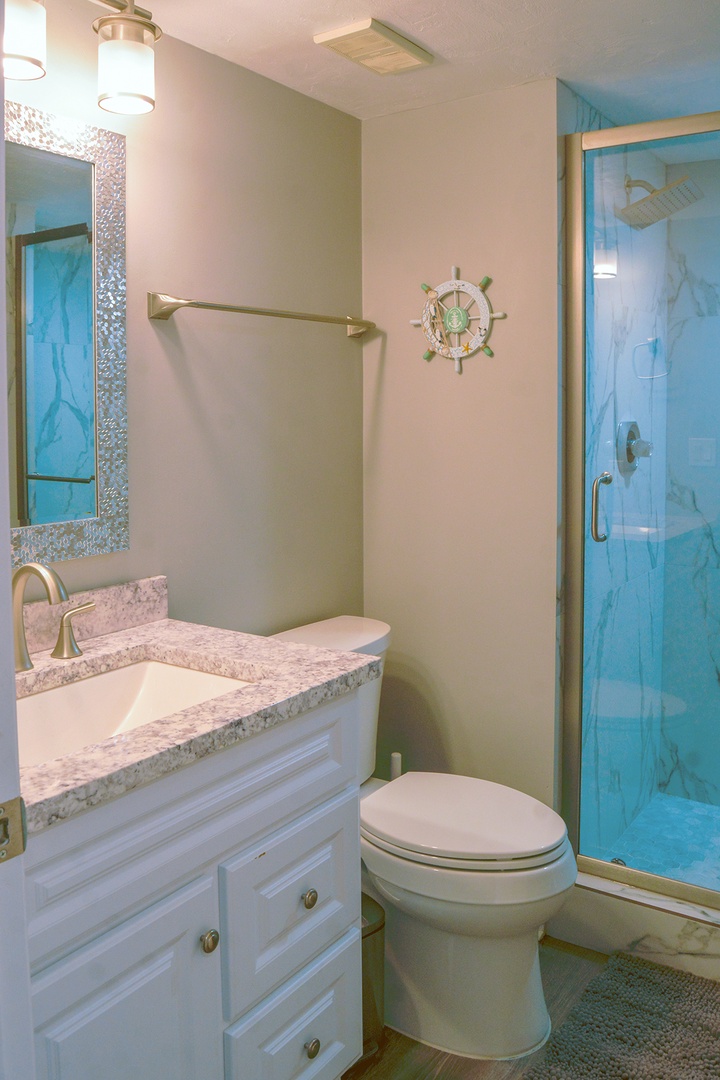 Your private bathroom features ocean-inspired décor with a sparkling tile mirror, granite vanity, and refreshing glass shower.