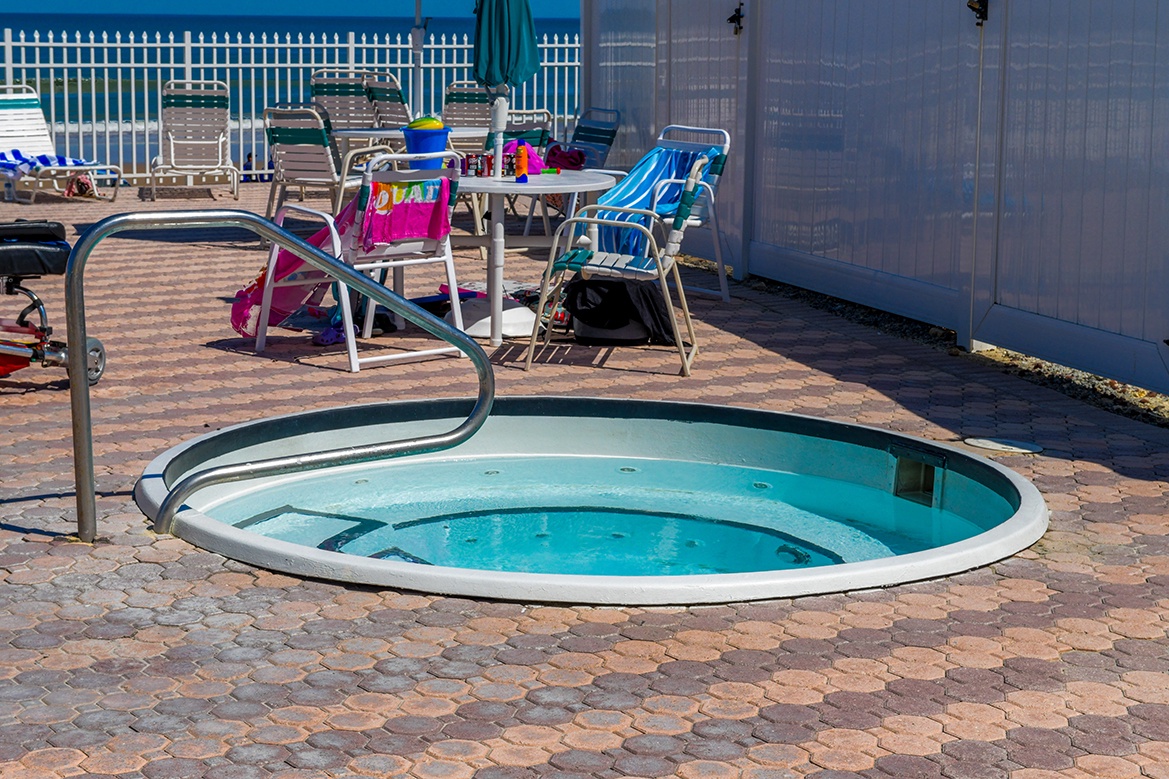 Soak your worries away in the bubbling hot tub, surrounded by comfortable poolside seating for the perfect relaxation experience.