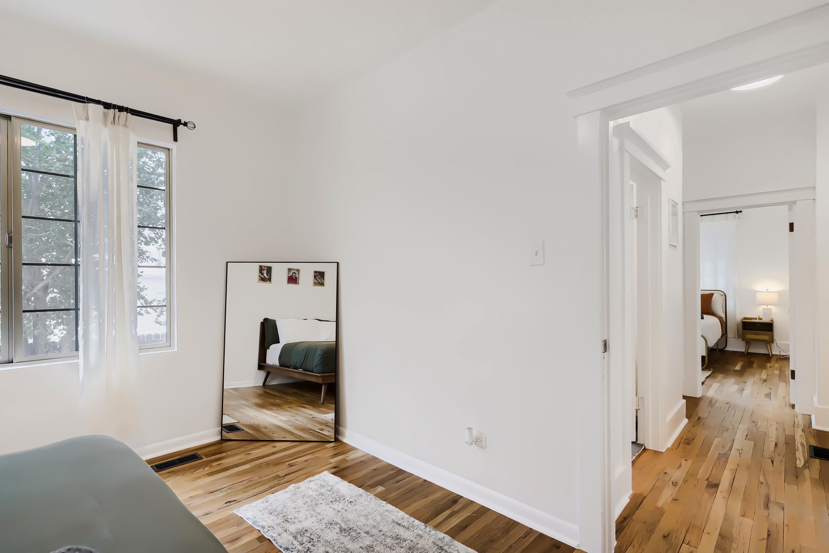 Bright, airy space with gleaming hardwood floors and natural light streaming through tall windows. You'll love the peaceful, minimalist design that flows seamlessly into cozy bedrooms.