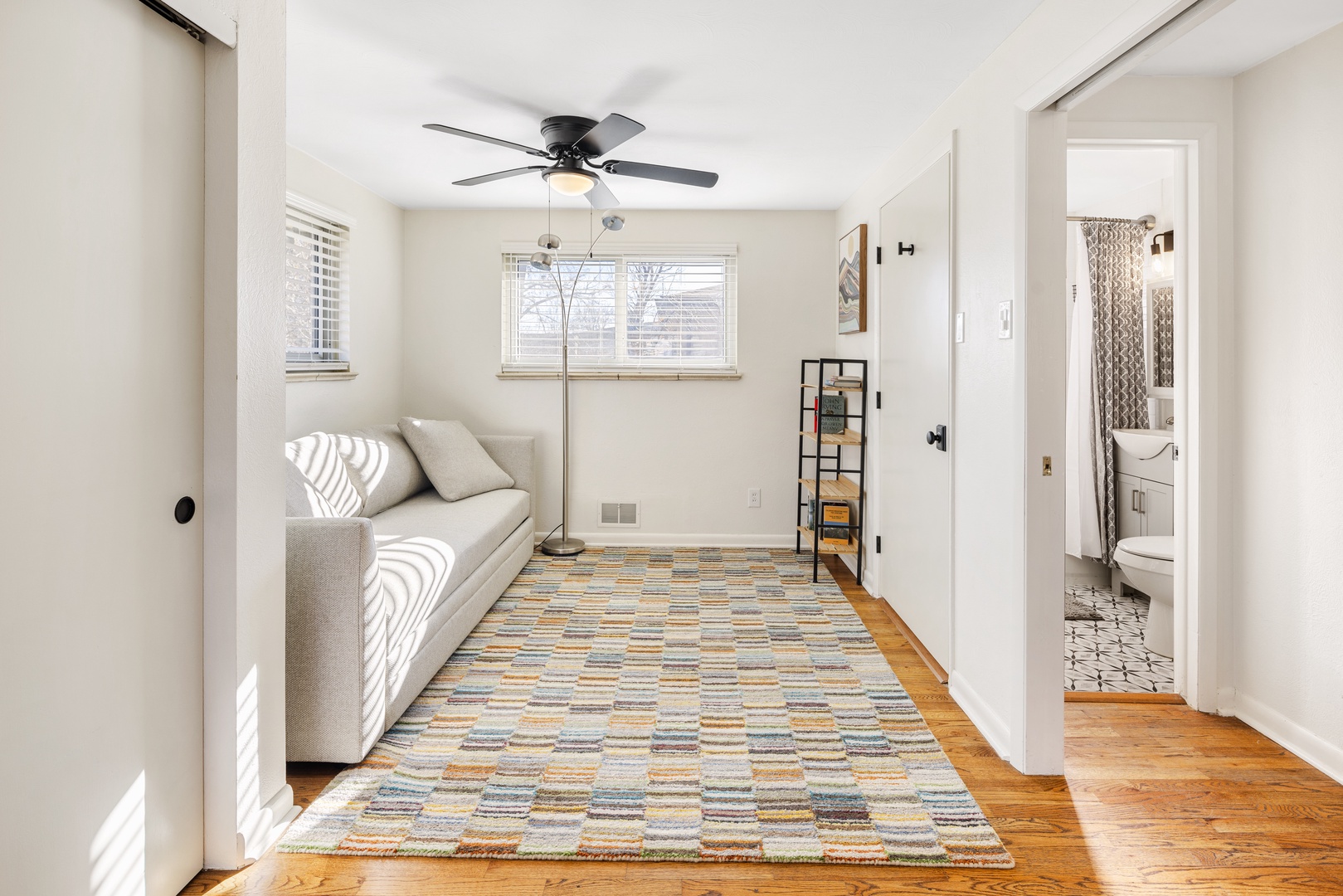 Relax in your bright living space with comfortable seating and natural light streaming through large windows.