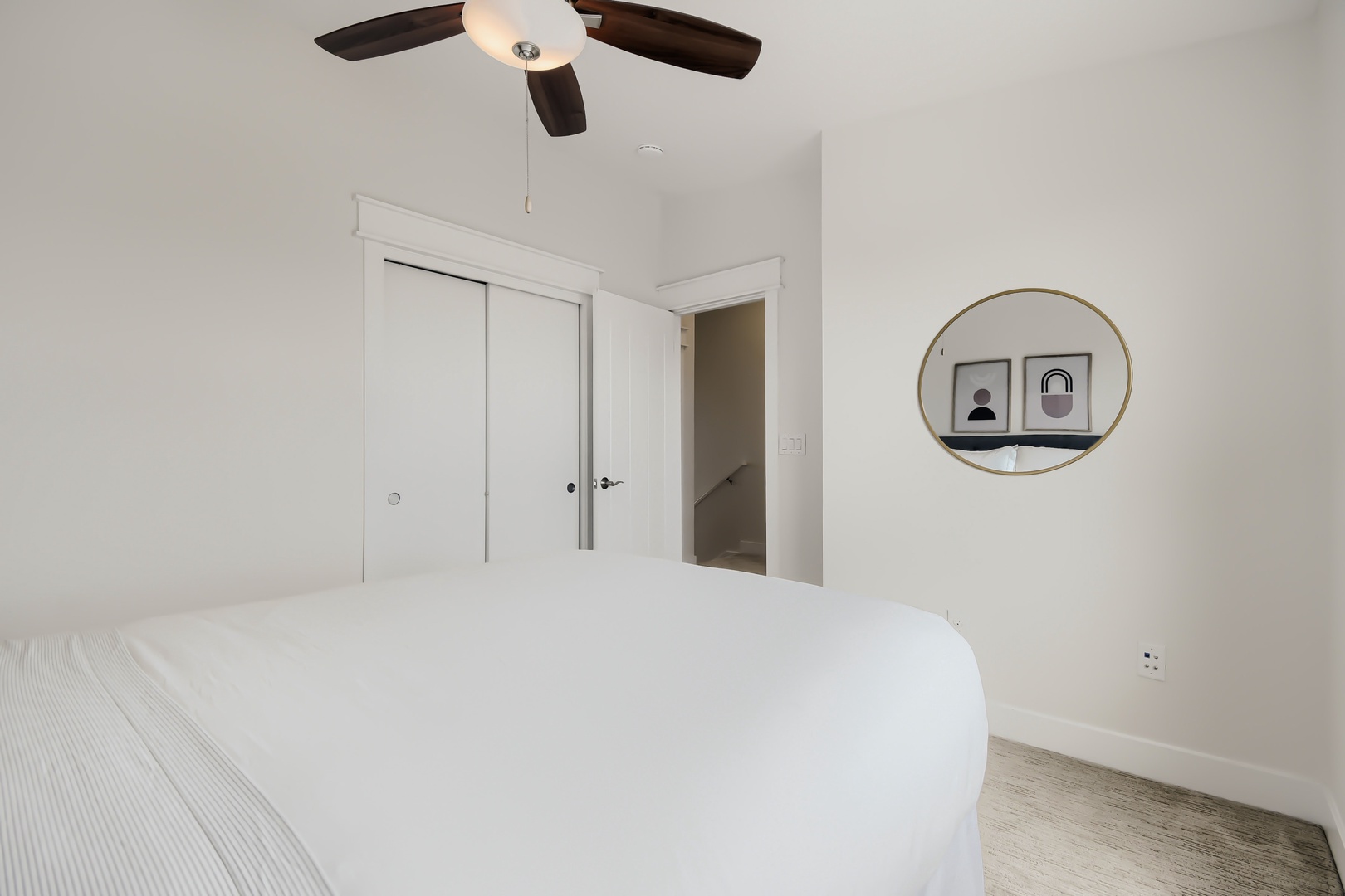 Drift off under soft ceiling fan breezes in your serene, light-filled bedroom with minimalist décor and a plush bed waiting to cradle you into restful sleep.