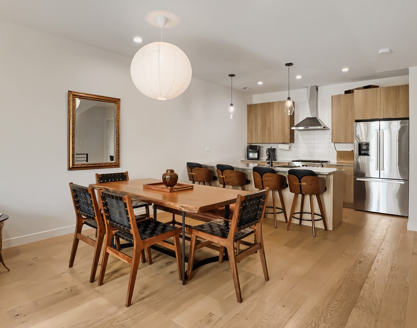 Gather around this inviting dining space where warm wood tones and modern design create the perfect setting for your morning coffee or evening meals with loved ones.