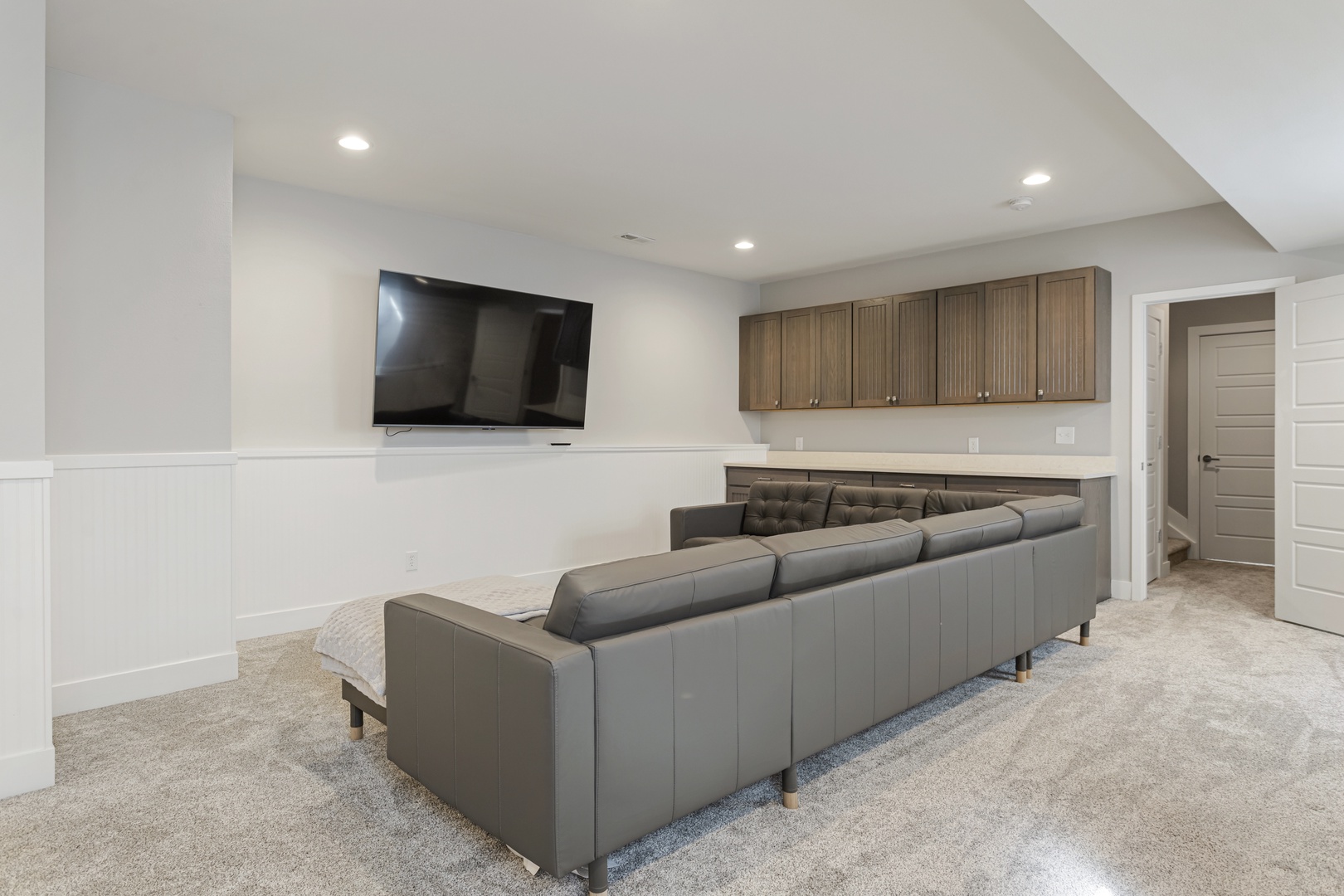 Sink into plush leather seating in your private entertainment space, where movie nights become unforgettable experiences with wall-mounted TV and ample storage.