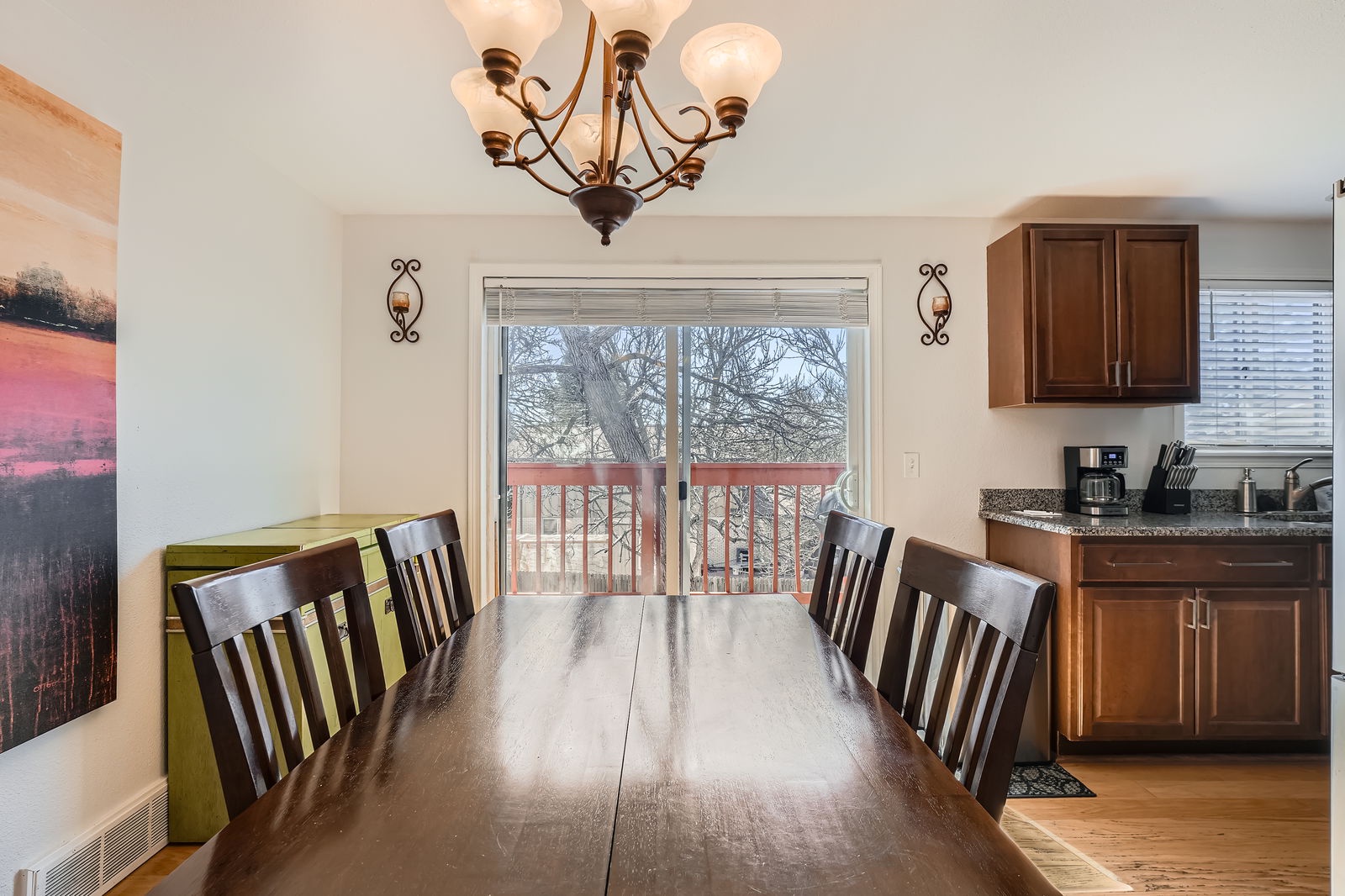 Gather around this warm dining table where your morning coffee tastes better with natural light streaming through the windows.