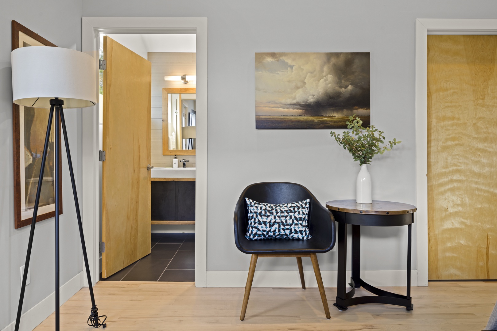 Settle into your stylish reading nook with modern furnishings, warm lighting, and thoughtful artwork creating the perfect retreat.