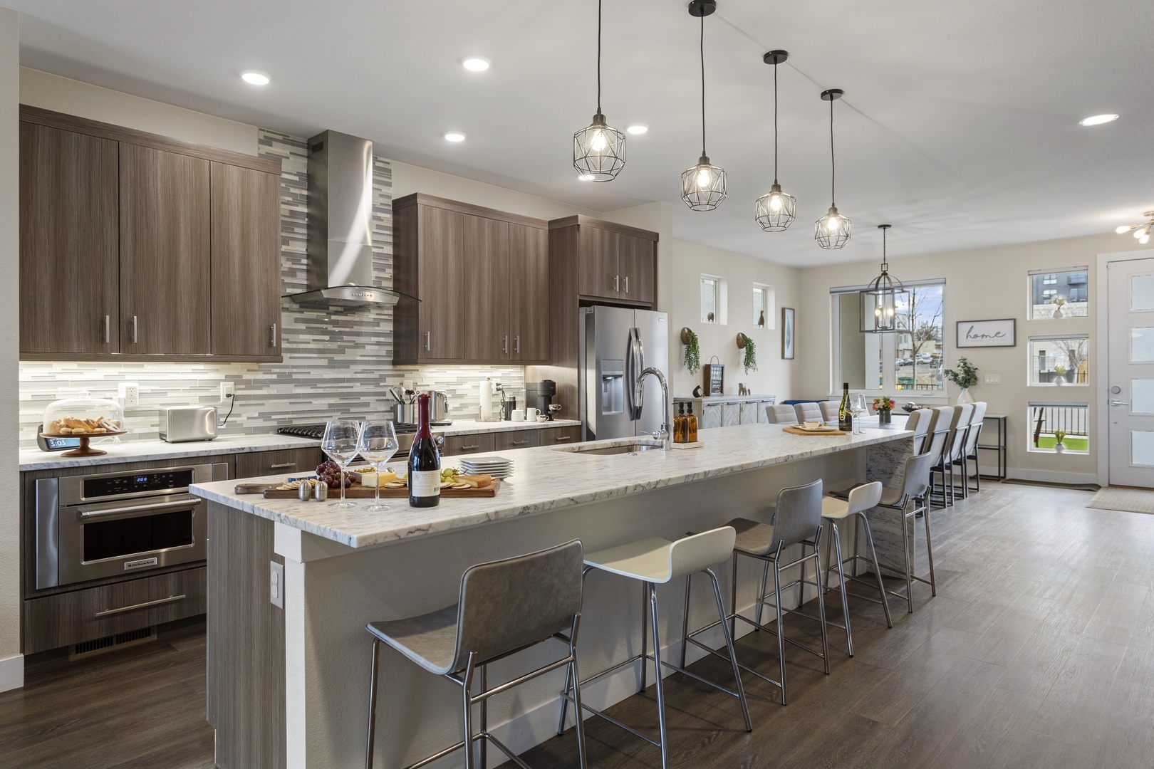 You'll love preparing meals in this modern kitchen with granite countertops, stainless steel appliances, and spacious island seating for eight.