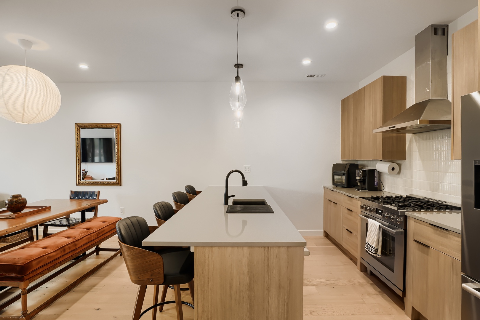 Your open-concept kitchen and dining space awaits, featuring warm wood cabinetry, modern appliances, and a welcoming island—perfect for gathering over home-cooked meals and making memories together.