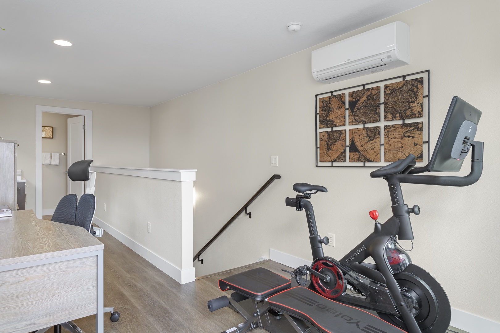 Stay active in your private fitness loft, featuring a stationary bike and workout bench in a bright, air-conditioned space.