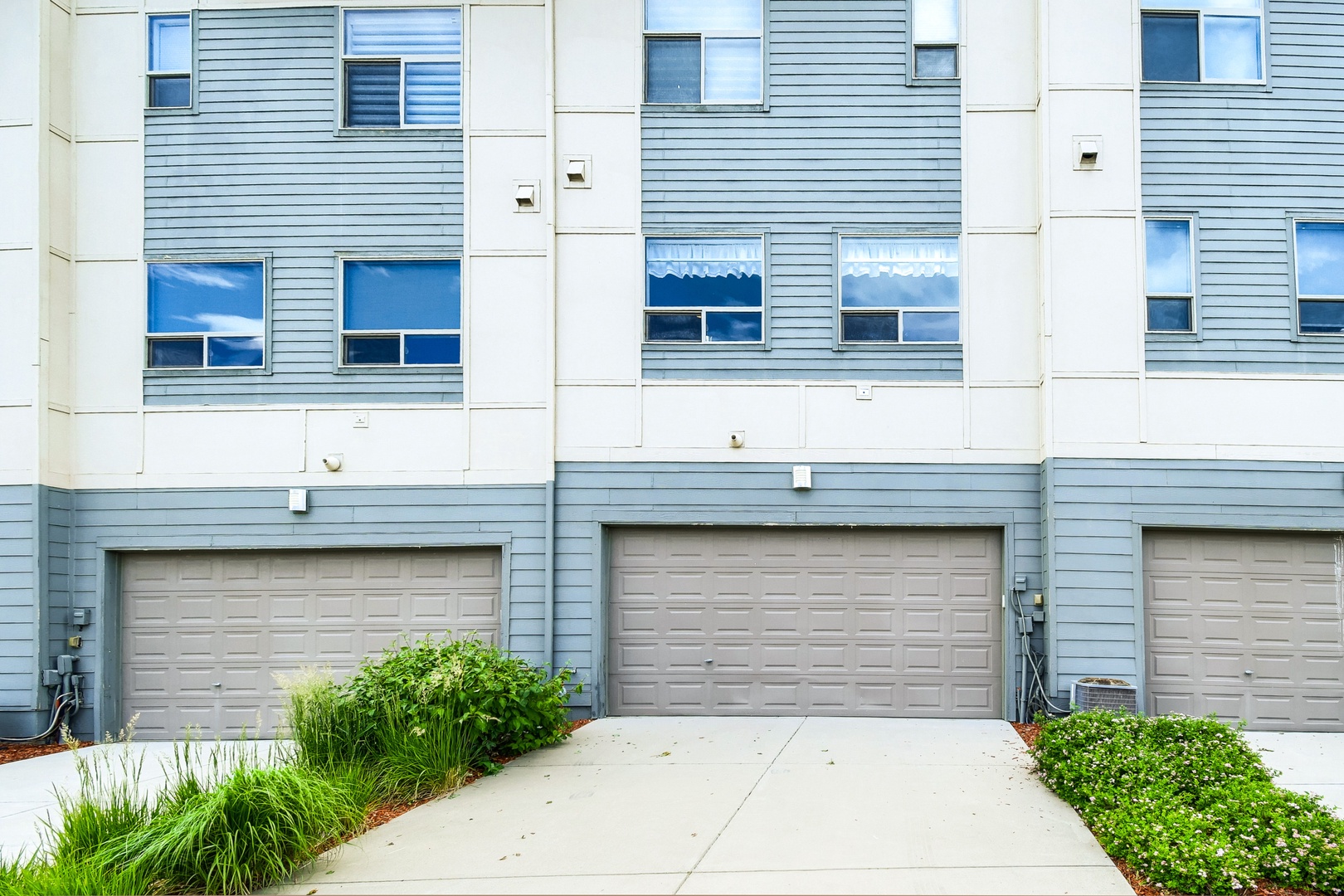 Modern townhome-style vacation rental with private garage parking and charming coastal curb appeal in a residential neighborhood.