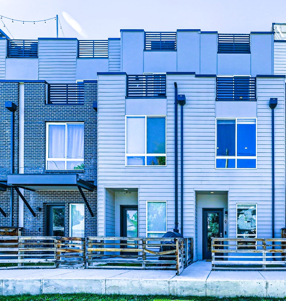 Modern townhomes featuring contemporary design with brick and siding exteriors in a well-maintained residential community.