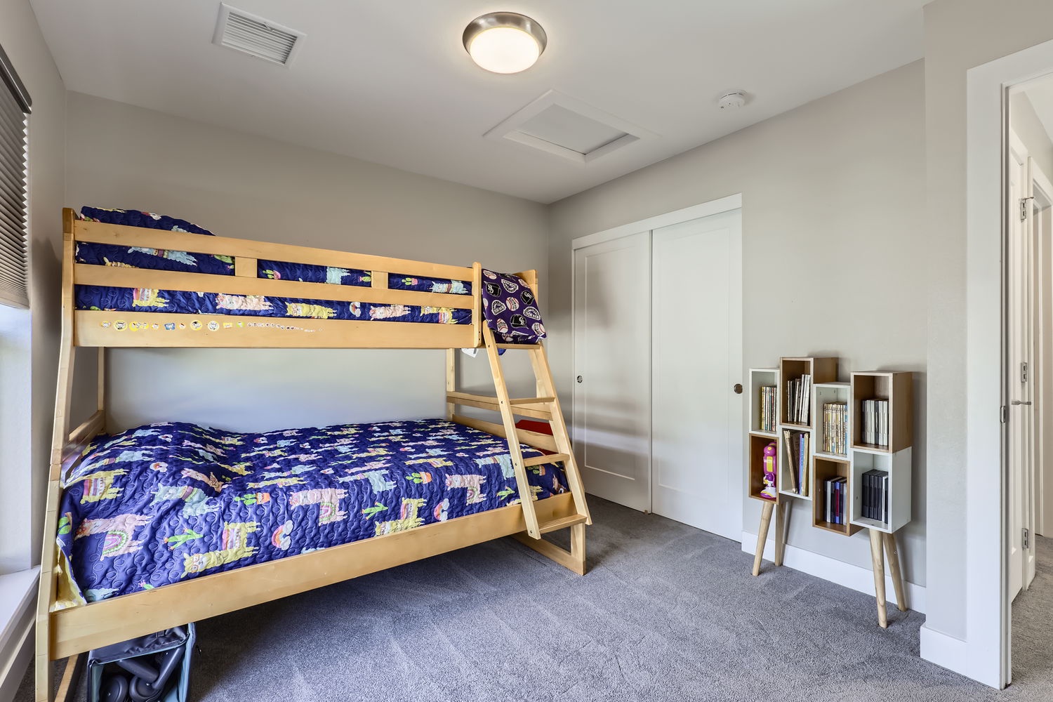 Settle into your comfortable space-themed bunk room, where playful bedding and thoughtful touches like a bookshelf create a cozy retreat for kids or groups.