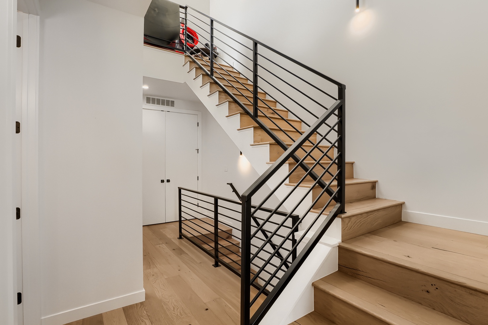 Your private stairway connects the home's levels with sleek modern railings and warm wood steps, all bathed in natural light.