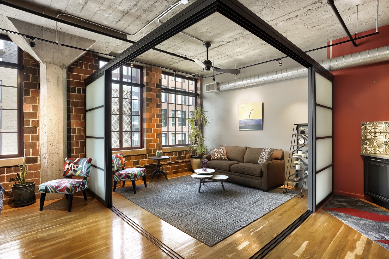 Sink into this stylish loft living space where exposed brick meets modern comfort. Your urban retreat awaits with cozy seating, industrial charm, and warm wood floors that make you feel instantly at home.