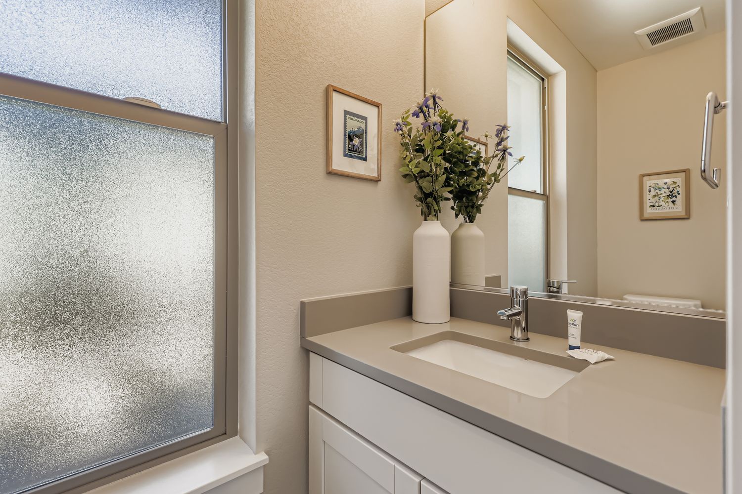 Step into your serene private bathroom, where soft natural light filters through frosted glass. Fresh flowers and a modern vanity create a spa-like atmosphere for your morning routine.