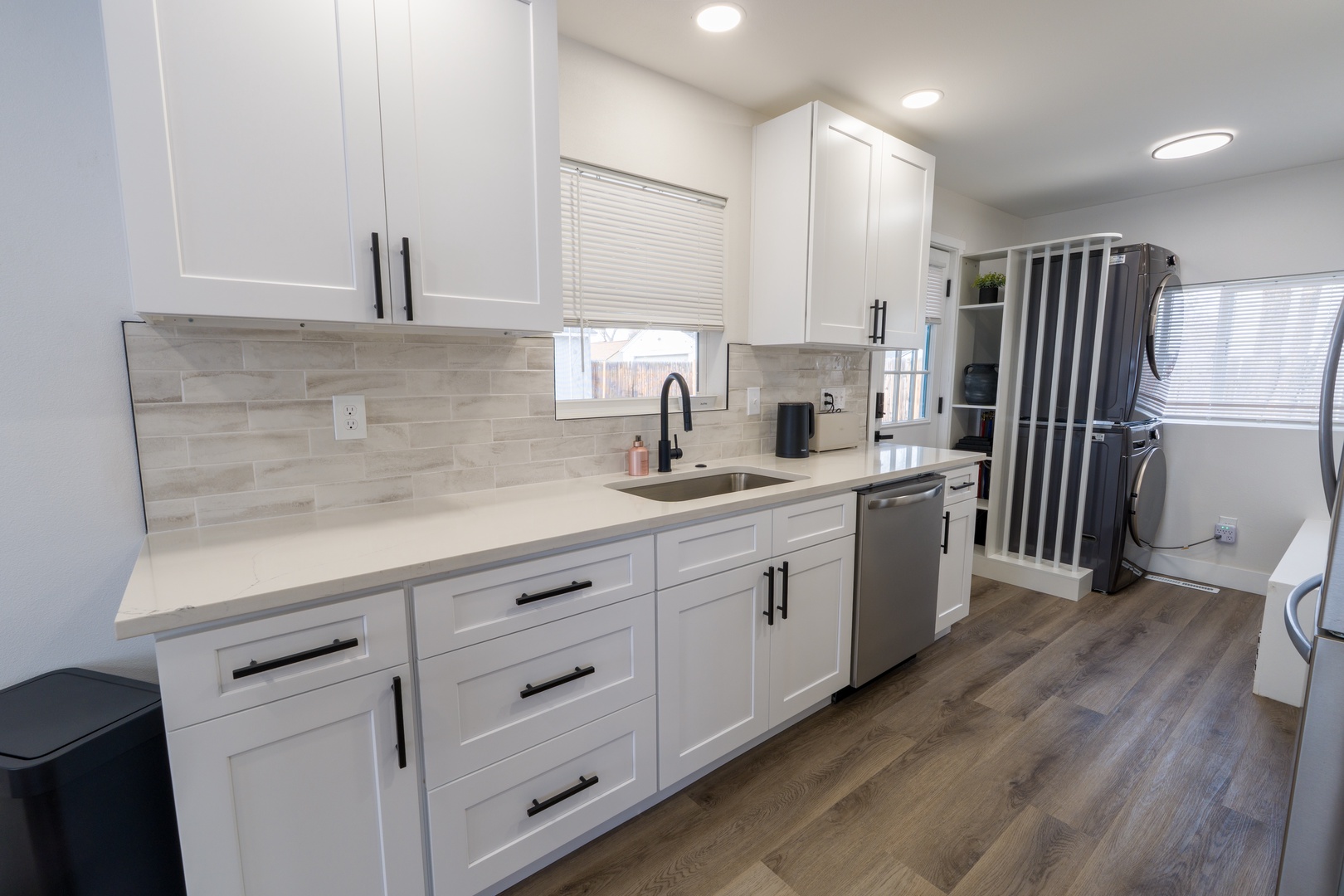 Your modern kitchen features pristine white cabinets, quartz countertops, and stainless steel appliances for effortless meal preparation.