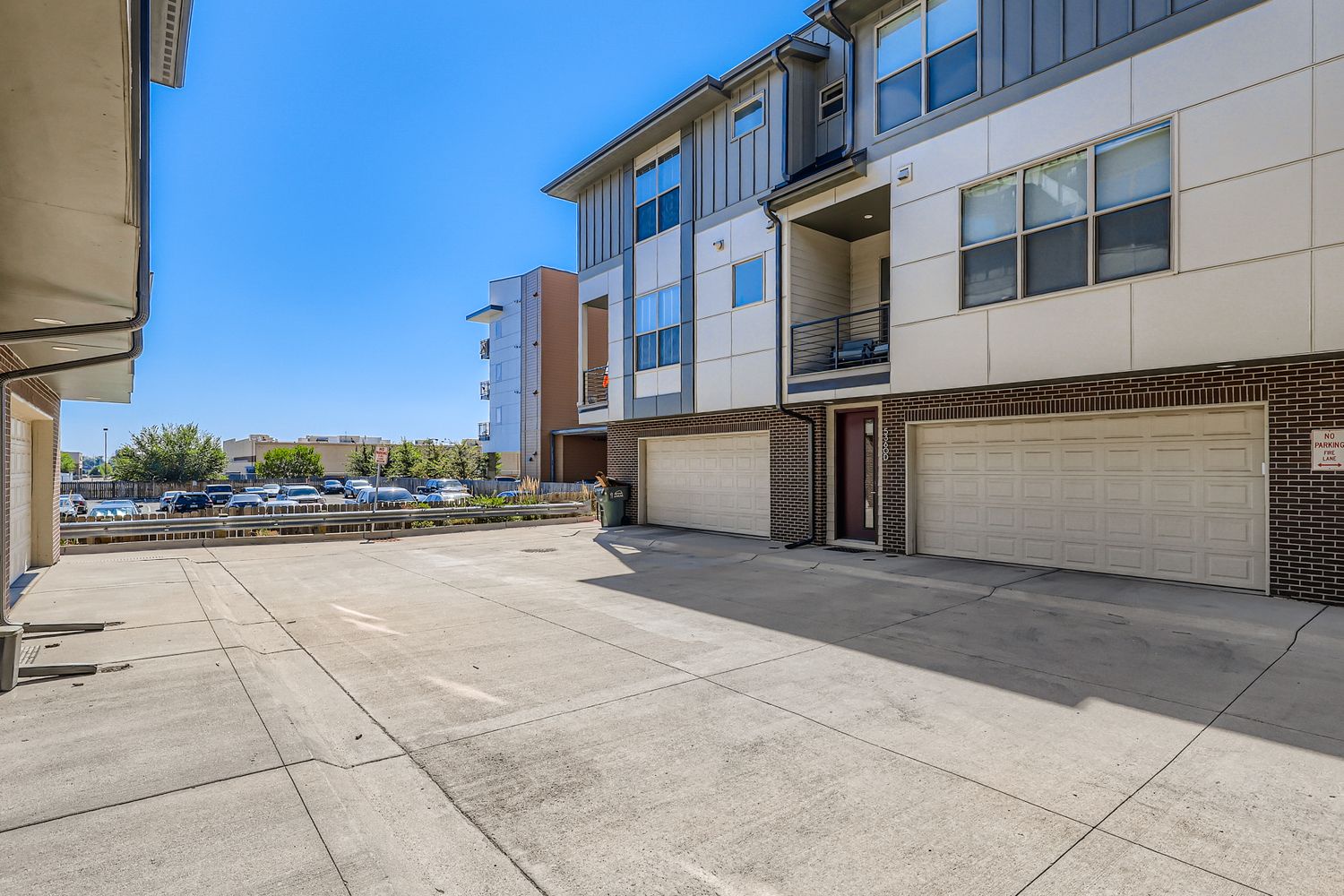 Modern multi-level townhome complex with private garages and convenient parking for each unit.