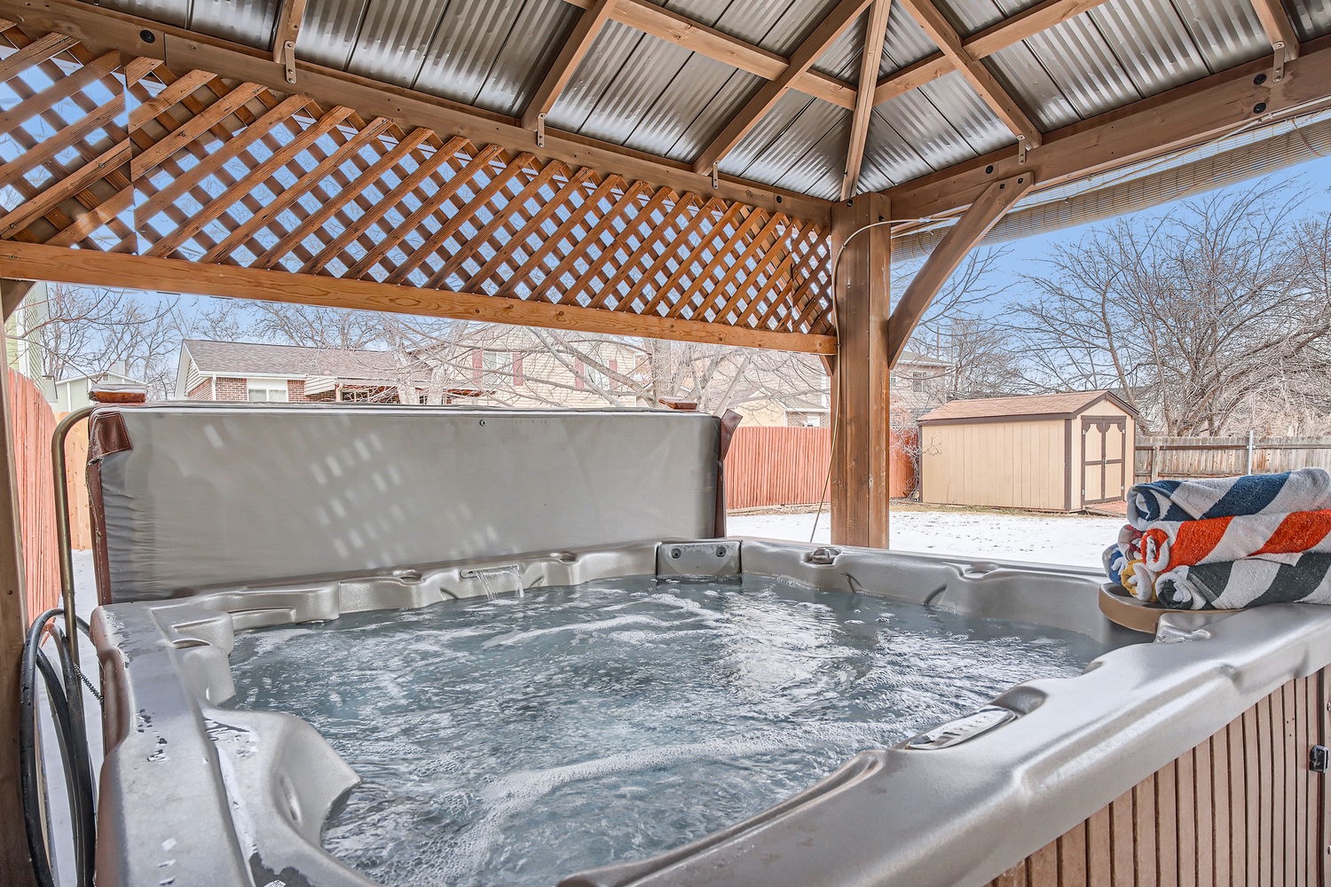 Slip into your private hot tub under a charming covered gazebo and let the warm, bubbling water melt away the day. The cozy seating and peaceful backyard setting make it your perfect retreat after exploring.