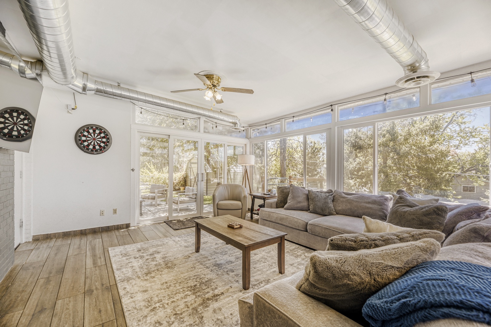 Sink into this bright, airy lounge with plush seating and natural light streaming through expansive windows. Play darts, unwind with games, and enjoy peaceful tree-lined views.