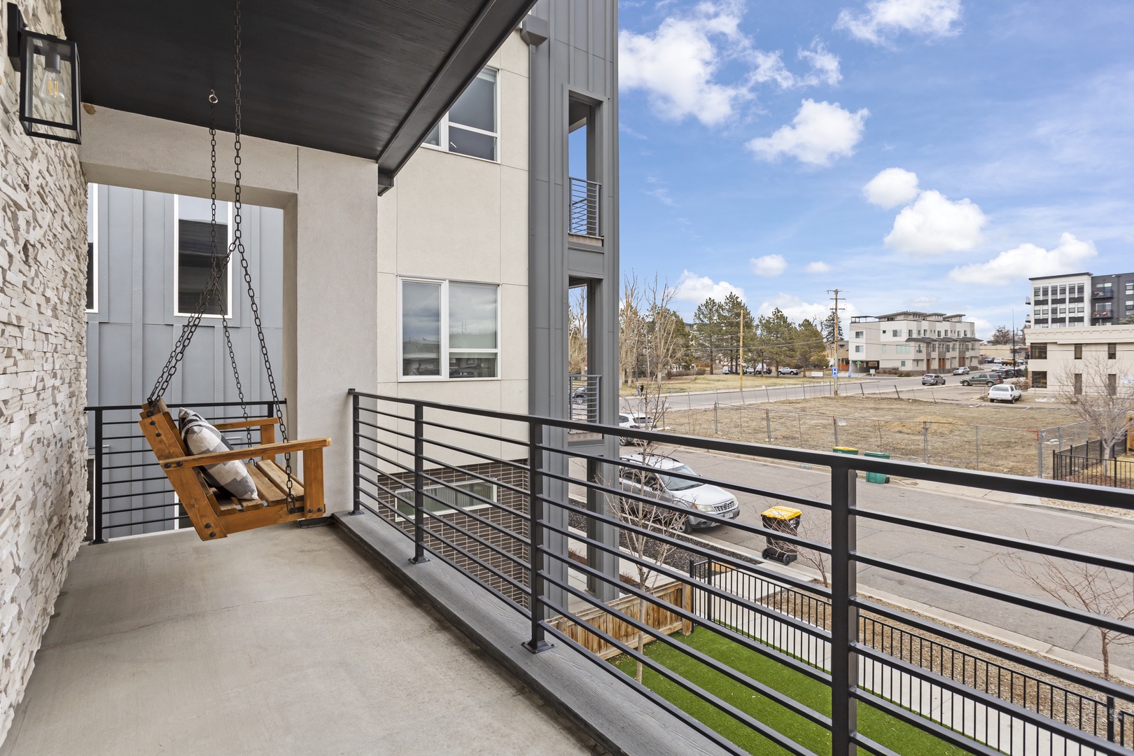 Sway gently on your private porch swing while taking in the peaceful neighborhood views from your modern balcony retreat.