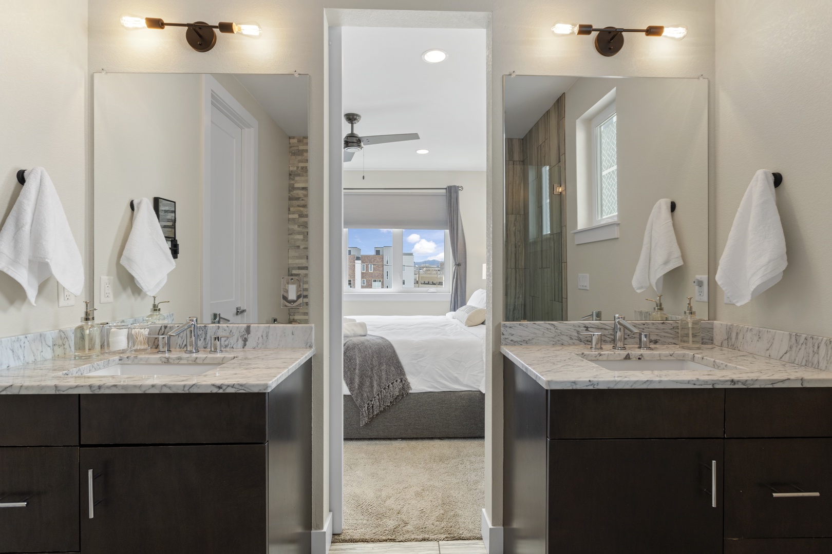 Luxurious dual vanity bathroom offers marble counters, elegant fixtures, and pristine towels for your refreshing morning routine.
