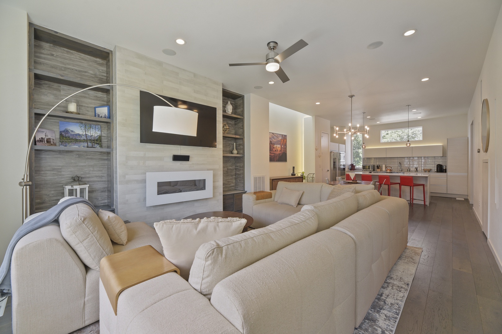 Sink into plush seating while your favorite show plays on the mounted TV. Stylish built-ins frame the modern fireplace, and the open layout connects you to the kitchen for easy entertaining.